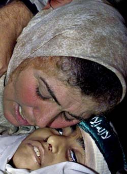 The mother of 9-year-old Palestinian girl Hanneen Abu Suleiman cries over her body before the funeral in the Khan Younis refugee camp in the southern Gaza Strip on Sunday. Israeli occupation troops shot Hanneen as she played outside her home on Saturday (ap photo, Jordan Times, 12/30/02). 