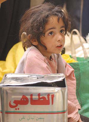 An Iraqi girl waits at a food distribution centre in Baghdad on Thursday. A UN food agency appealed for $86 million to help farmers in Iraq protect crops and stave off disastrous food shortages. The appeal was part of a total $2.2 billion request by the United Nations (photo by Samir Mezban/AP, Jordan Times, 4/4/03). 